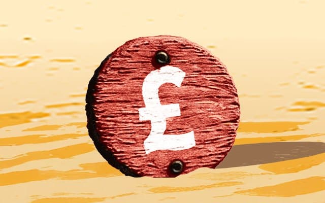 A deckchair and beach ball on the sand